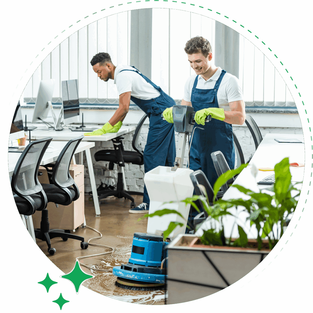 Two men in blue overalls cleaning a room.