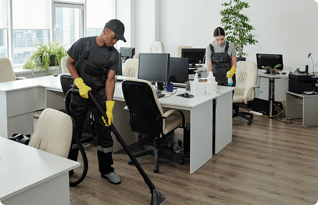 A man and woman cleaning an office with yellow gloves.